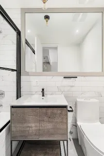 a bathroom with a sink toilet vanity and mirror