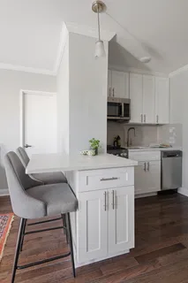 a kitchen with a white cabinets and chairs