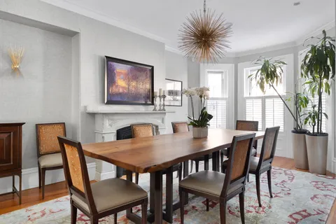 a view of a dining room with furniture and a potted plant