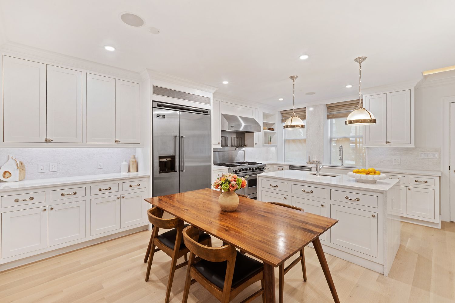 a kitchen with stainless steel appliances kitchen island granite countertop a kitchen island hardwood floor and a sink
