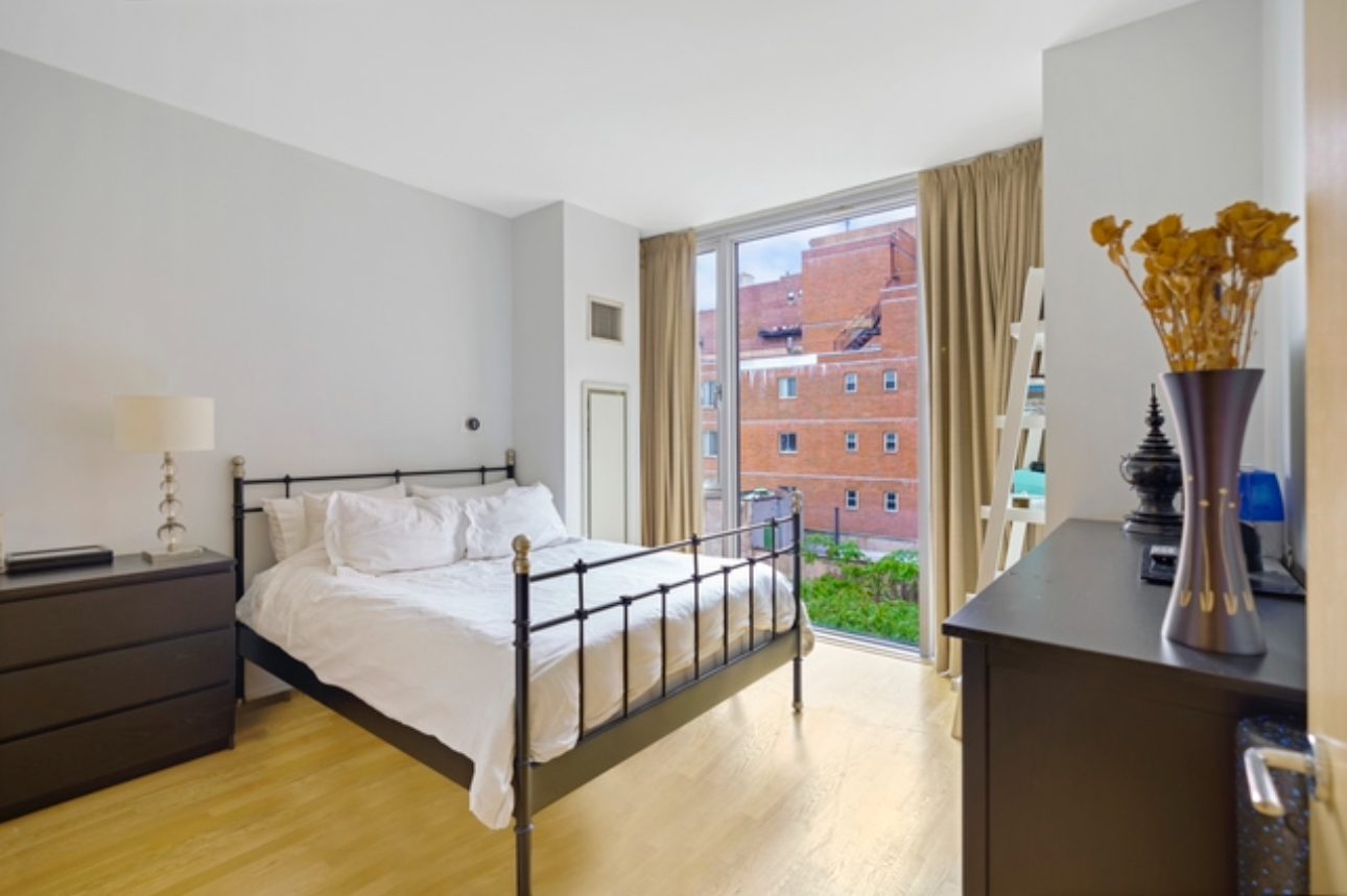 110 3rd Avenue, Unit 9B Manhattan, NY 10003 - Photo 6 of 14 a spacious bedroom with a bed and a flat tv screen on dresser