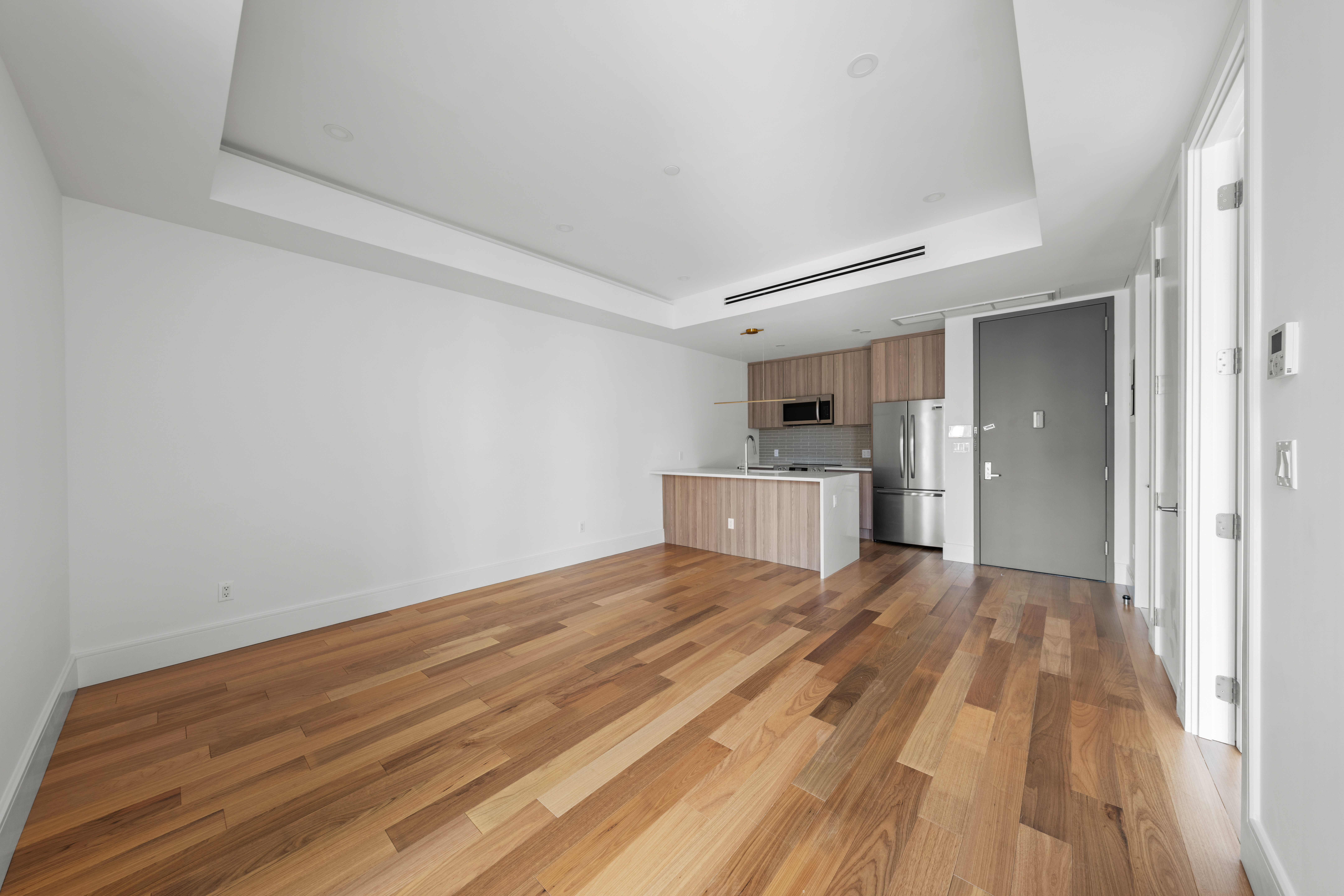82 Cooper Street, Unit 2B Brooklyn, NY 11207 - Photo 13 of 17 a view of a room with wooden floor and white walls