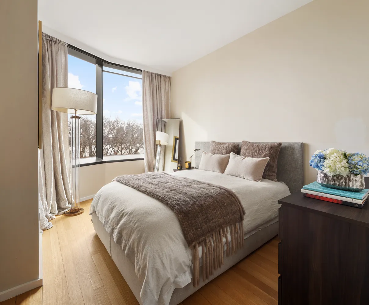 a bedroom with a bed and a large window