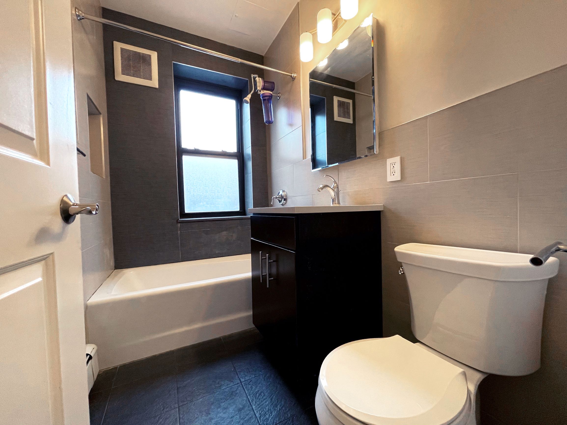 350 Irving Avenue, Unit 2F Brooklyn, NY 11237 - Photo 4 of 5 a bathroom with a sink a toilet a mirror and bathtub