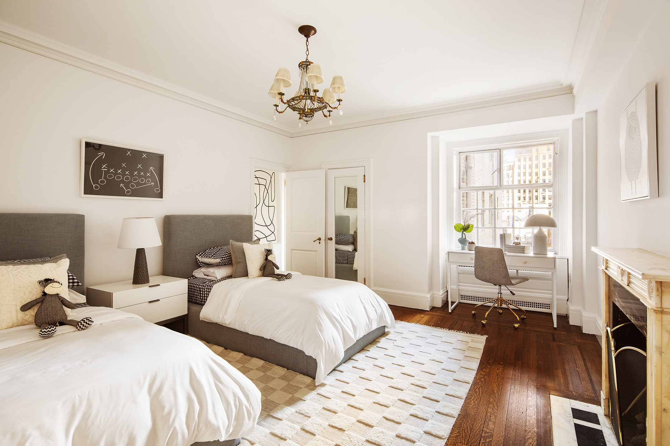 953 5th Avenue, Unit 7/8 Manhattan, NY 10075 - Photo 8 of 15 a bedroom with two beds and a chandelier