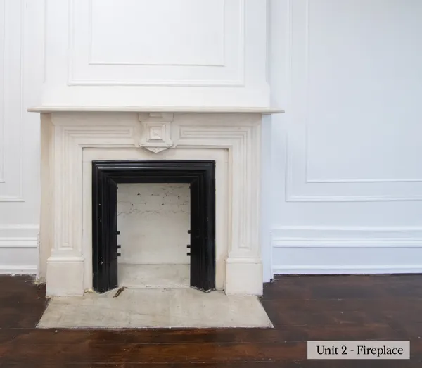 a view of an empty room with wooden floor and a fireplace