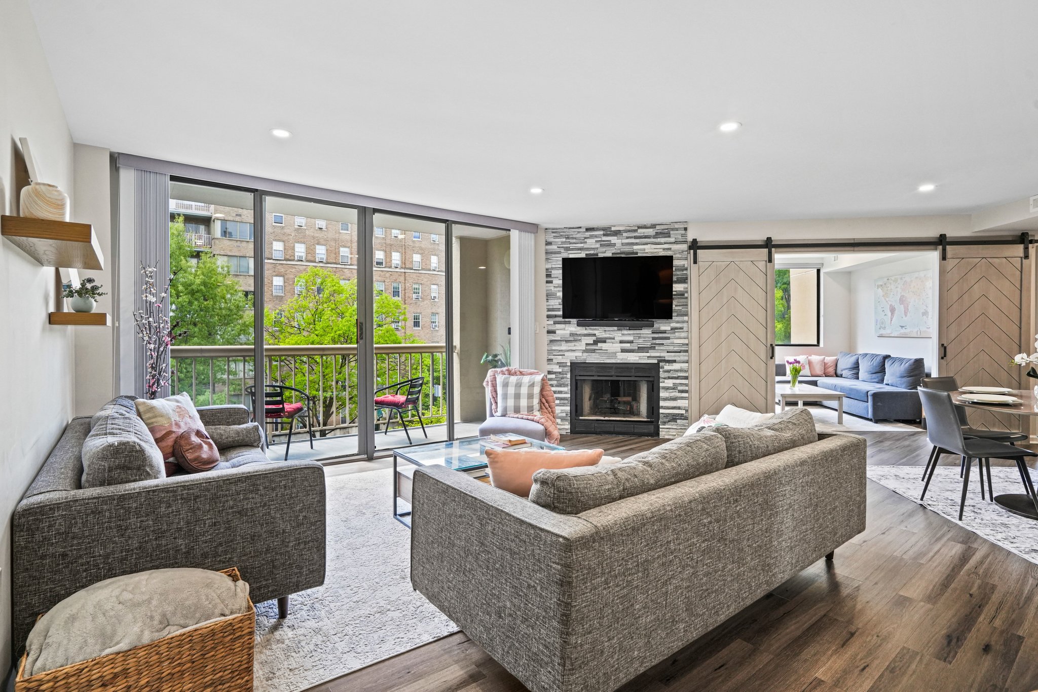 2725 Connecticut Avenue Northwest, Unit 507 Washington, DC 20008 - Photo 11 of 31 a living room with furniture a fireplace a flat screen tv and a large window