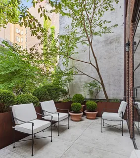 a view of backyard with outdoor seating and plants