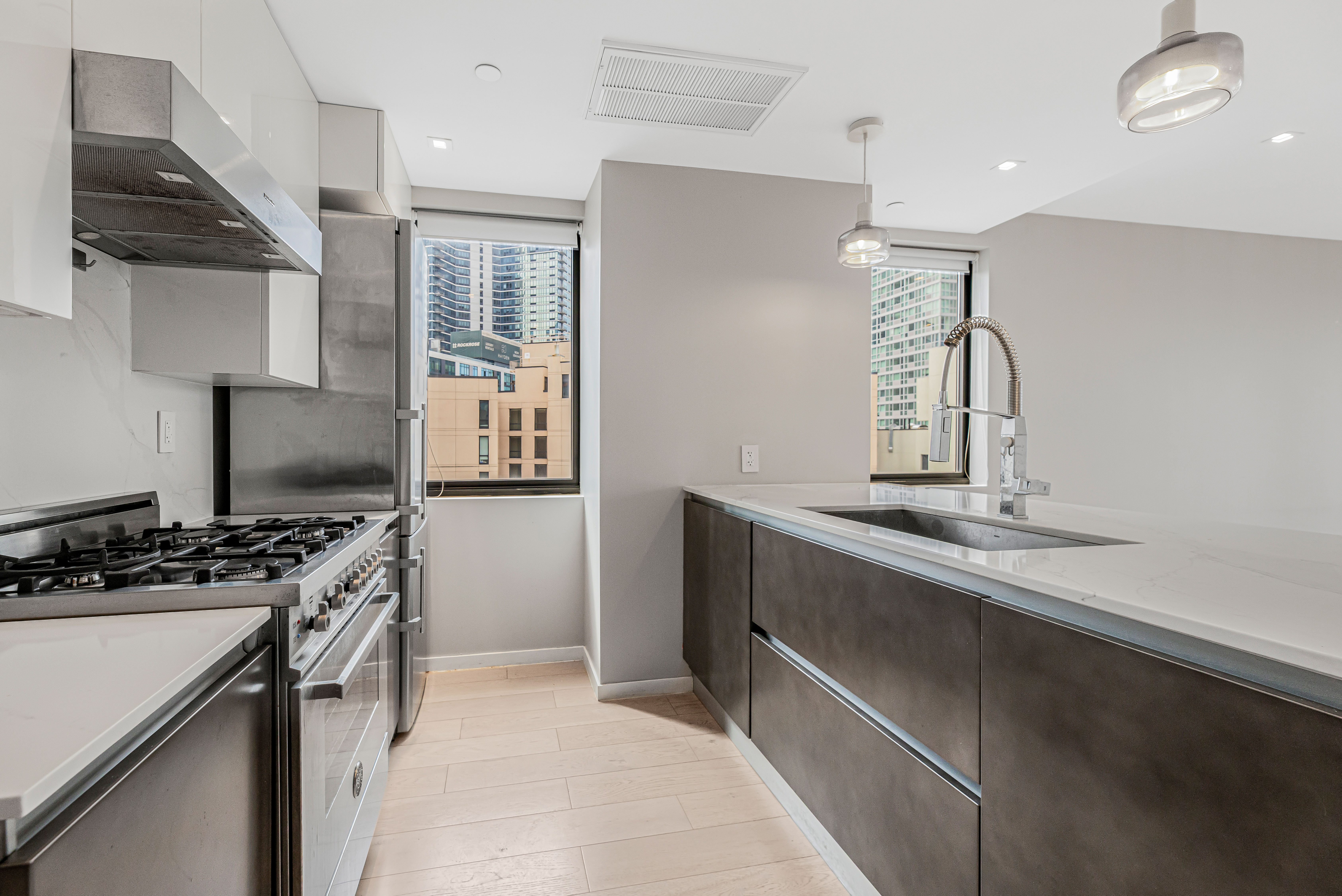 42-50 27th Street, Unit 9C Queens, NY 11101 - Photo 12 of 32 a kitchen with a stove and a refrigerator