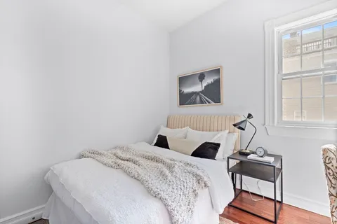 a bedroom with a bed and wooden floor