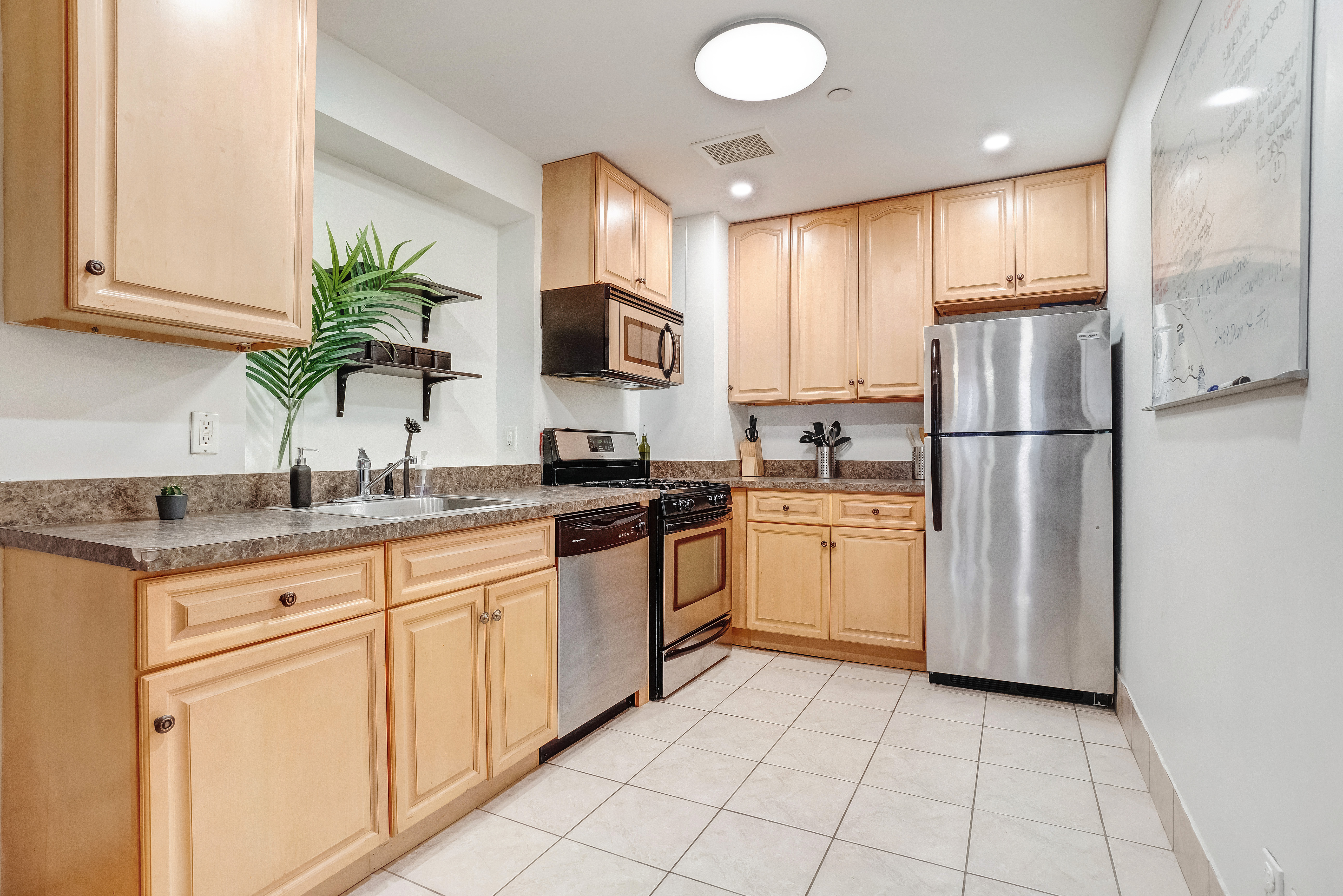 1570 Prospect Place, Unit 3 Brooklyn, NY 11233 - Photo 5 of 10 a kitchen with white cabinets stainless steel appliances and a sink