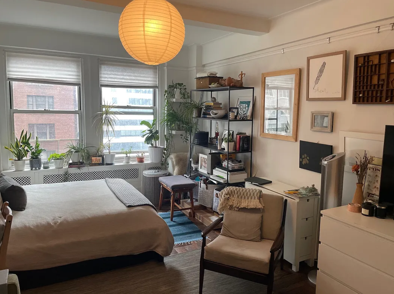433 West 34th Street, Unit 10C Manhattan, NY 10001 - Photo 3 of 8 a bedroom with a bed a bookshelf and a window