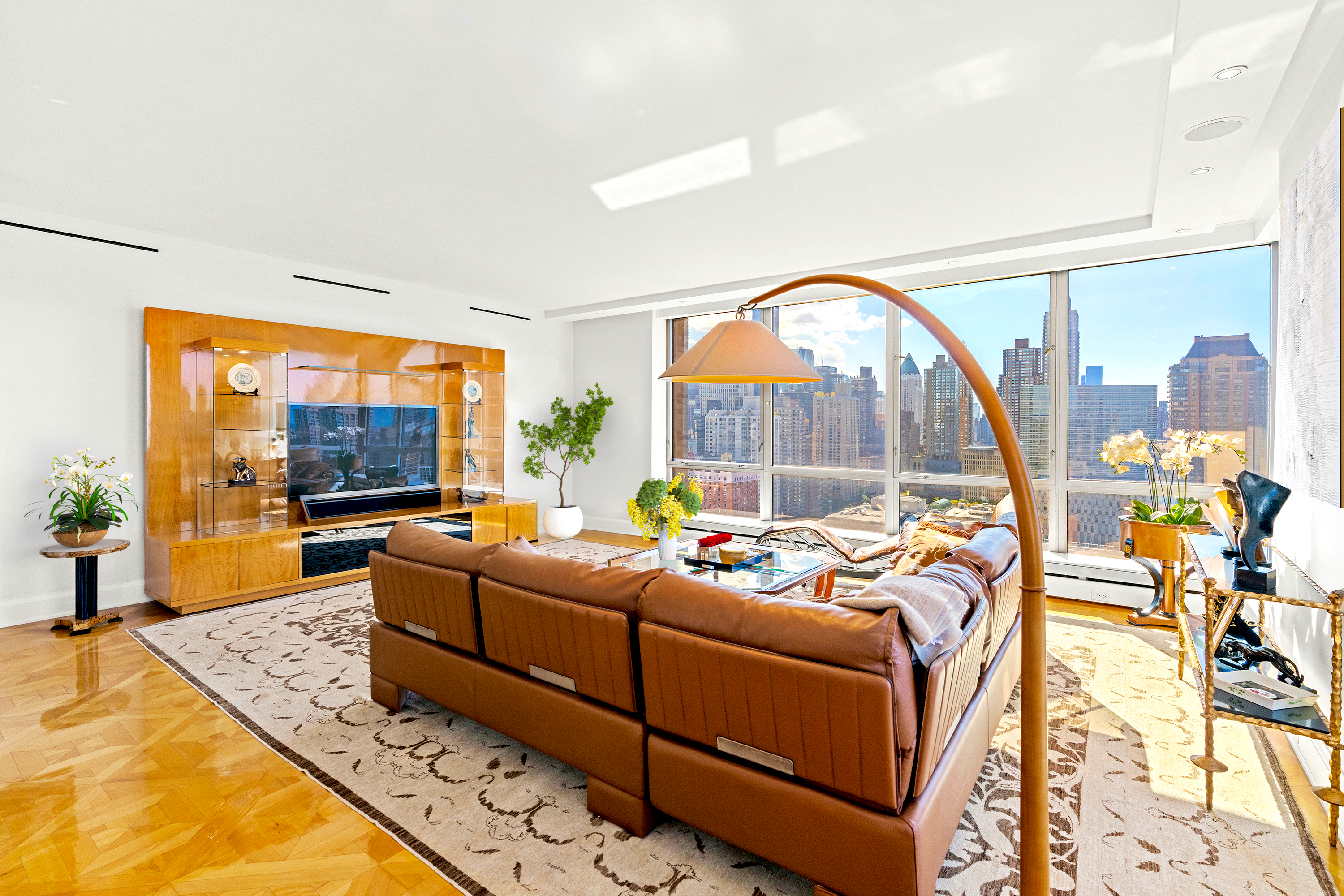 1965 Broadway, Unit 26EF Manhattan, NY 10023 - Photo 2 of 32 a living room with furniture a flat screen tv and a floor to ceiling window