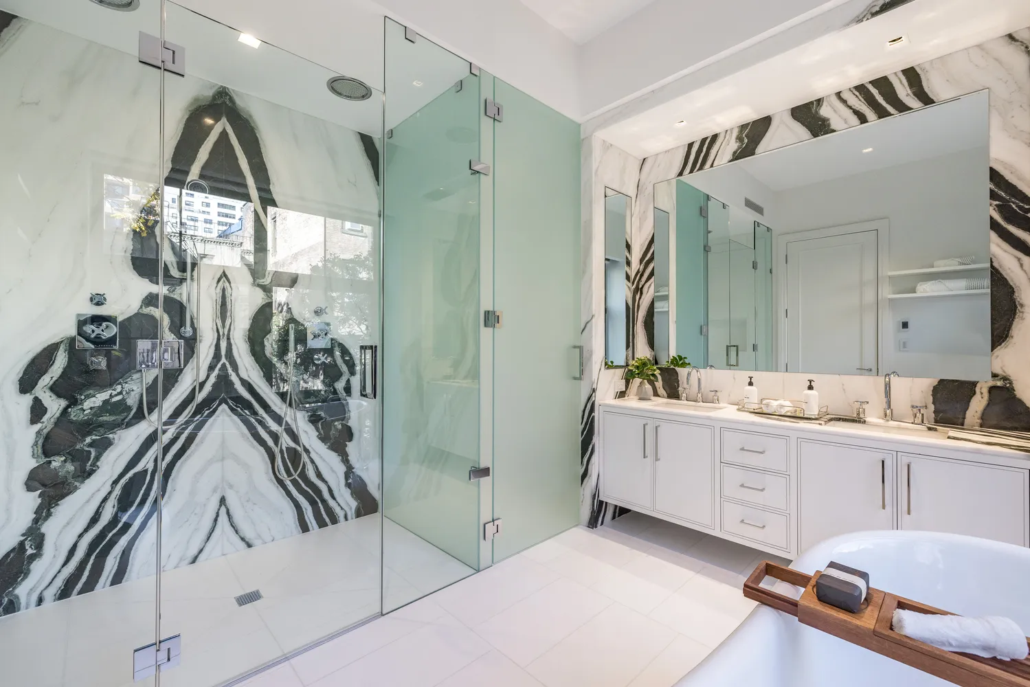 a large bathroom with a double vanity sink a mirror a bathtub and next to a window