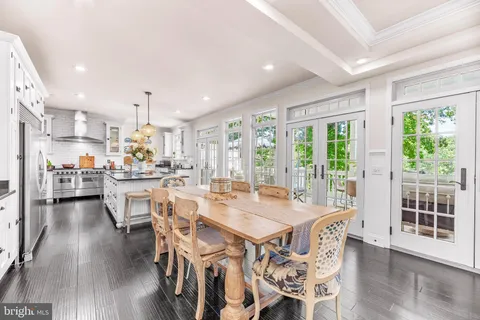 a kitchen with stainless steel appliances refrigerator dining table and chairs