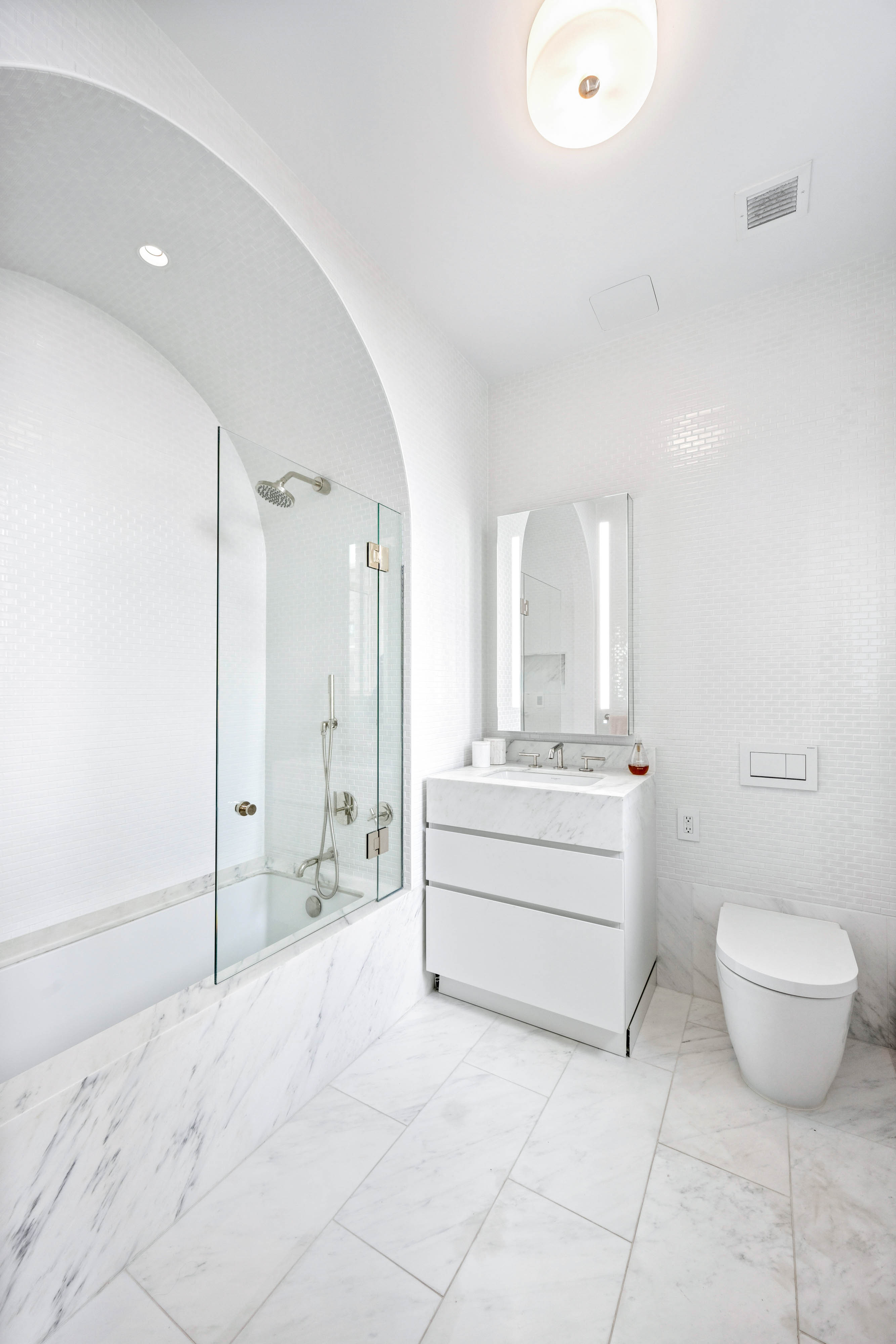 1228 Madison Avenue, Unit 11 Manhattan, NY 10128 - Photo 13 of 22 a bathroom with a double vanity sink toilet and mirror