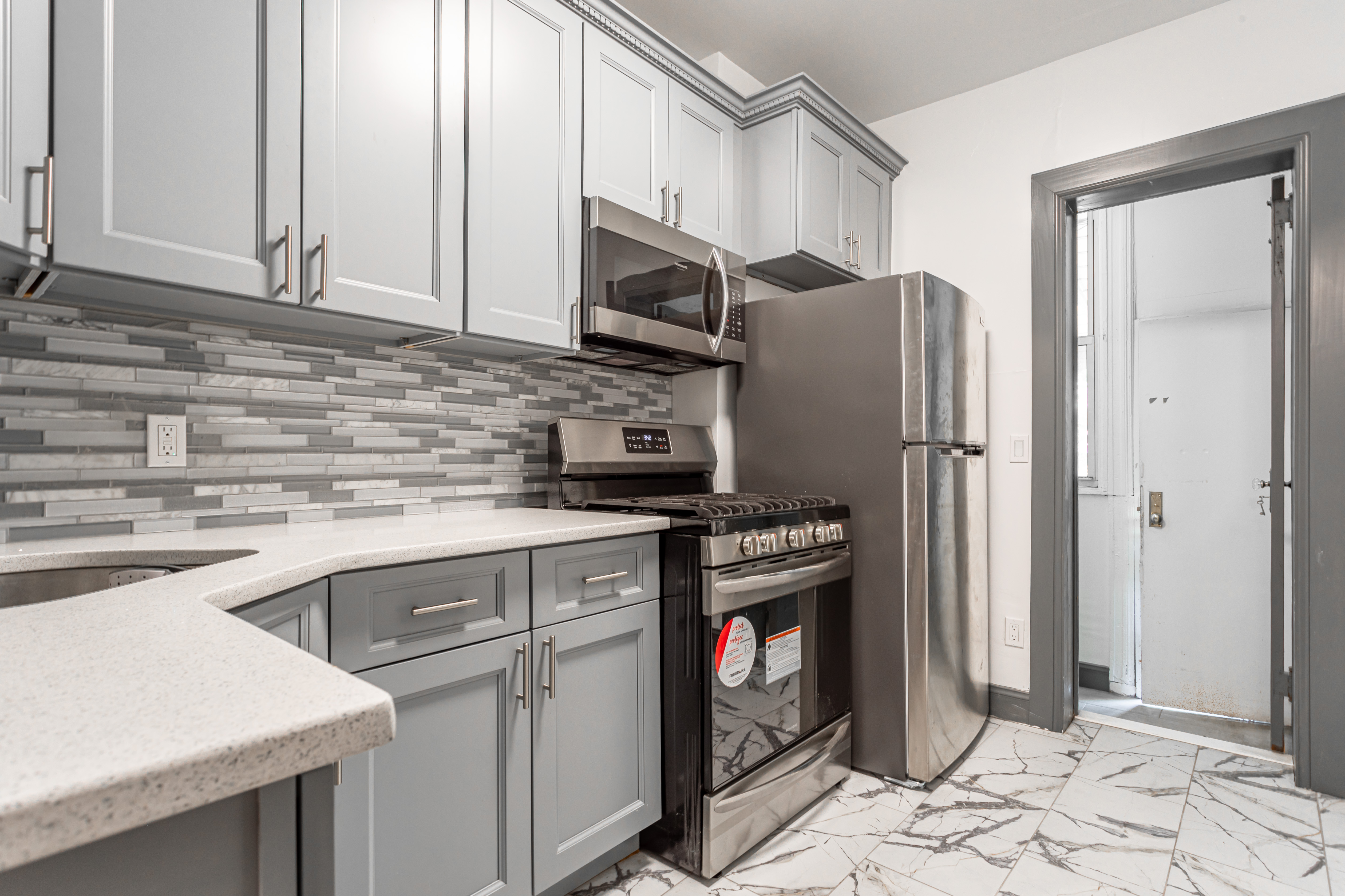 1191 Lincoln Place, Unit 1 Brooklyn, NY 11213 - Photo 7 of 13 a kitchen with stainless steel appliances granite countertop a refrigerator a stove a sink and a white cabinets