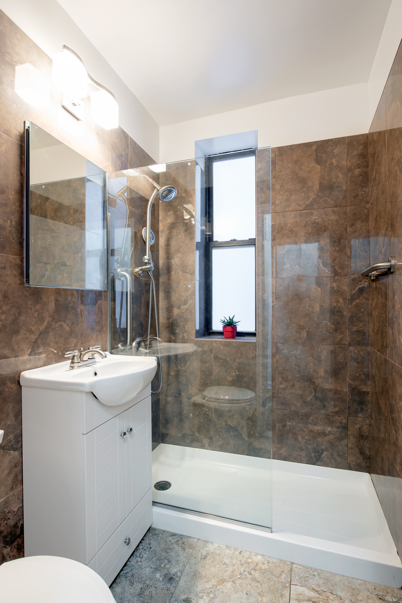140 Claremont Avenue, Unit 2F Manhattan, NY 10027 - Photo 3 of 6 a bathroom with a sink mirror toilet and bathtub