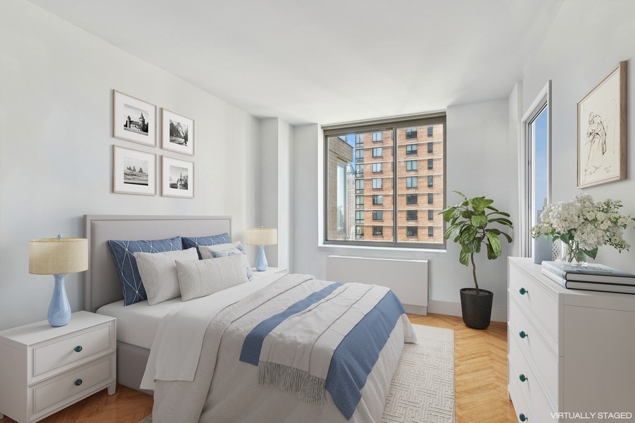 2 Columbus Avenue, Unit 23A Manhattan, NY 10019 - Photo 7 of 10 a bedroom with a bed and a potted plant