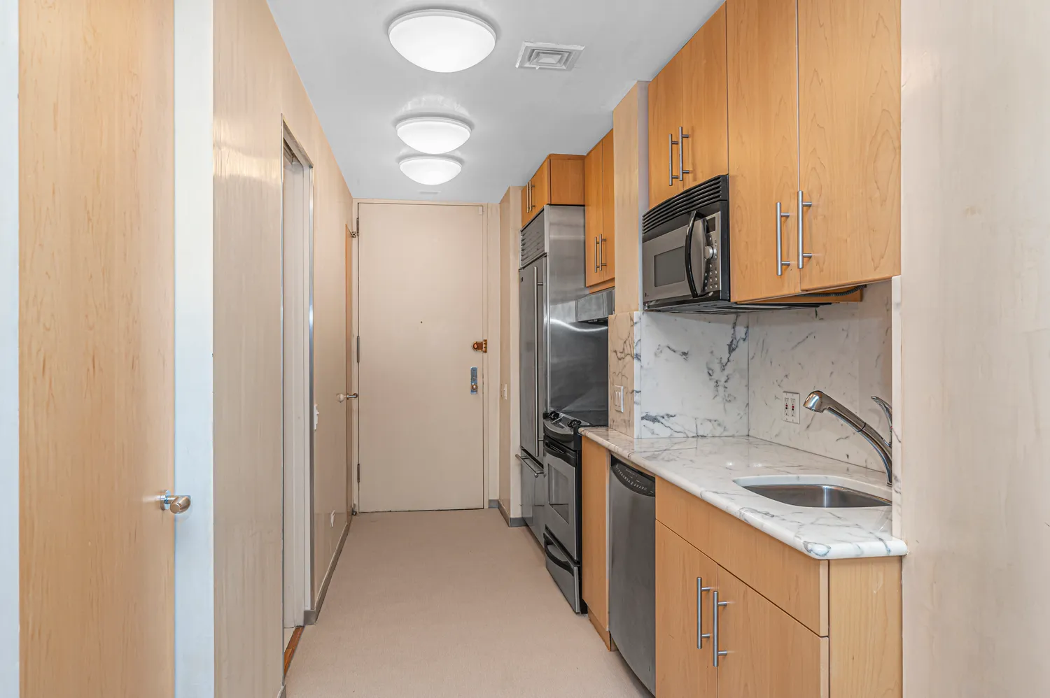a kitchen with a sink a refrigerator and a stove top oven