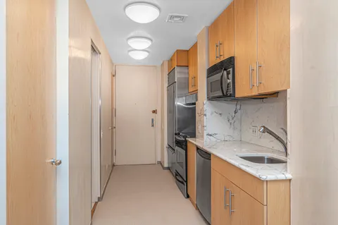 a kitchen with a sink a refrigerator and a stove top oven