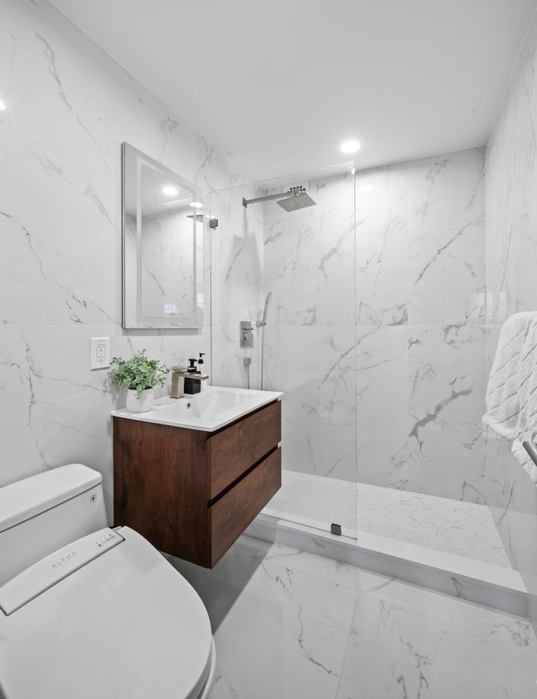 a bathroom with a sink a toilet and shower