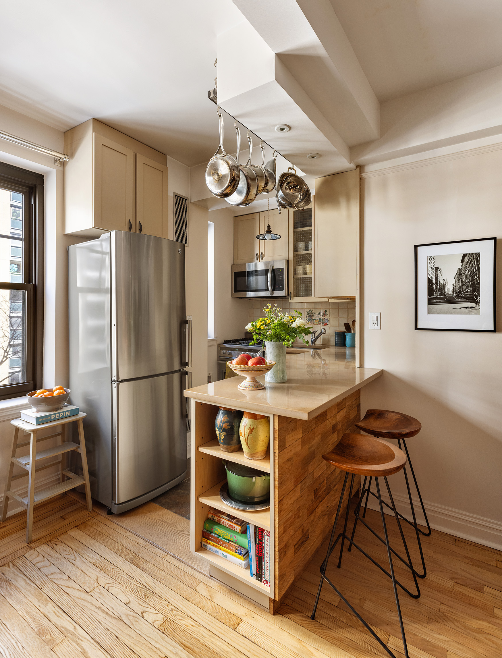 200 East 16th Street, Unit 5LM Manhattan, NY 10003 - Photo 3 of 16 a kitchen with stainless steel appliances a refrigerator a stove a sink dishwasher and a dining table with wooden floor