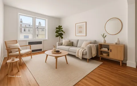 a living room with furniture a rug a lamp and a large window