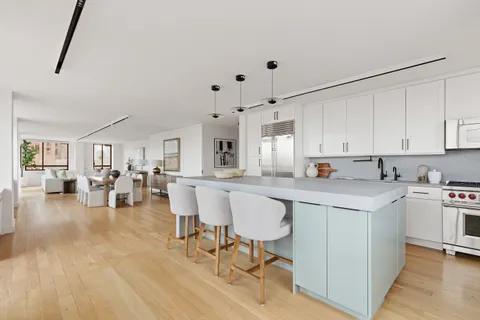 a kitchen with white cabinets and chairs