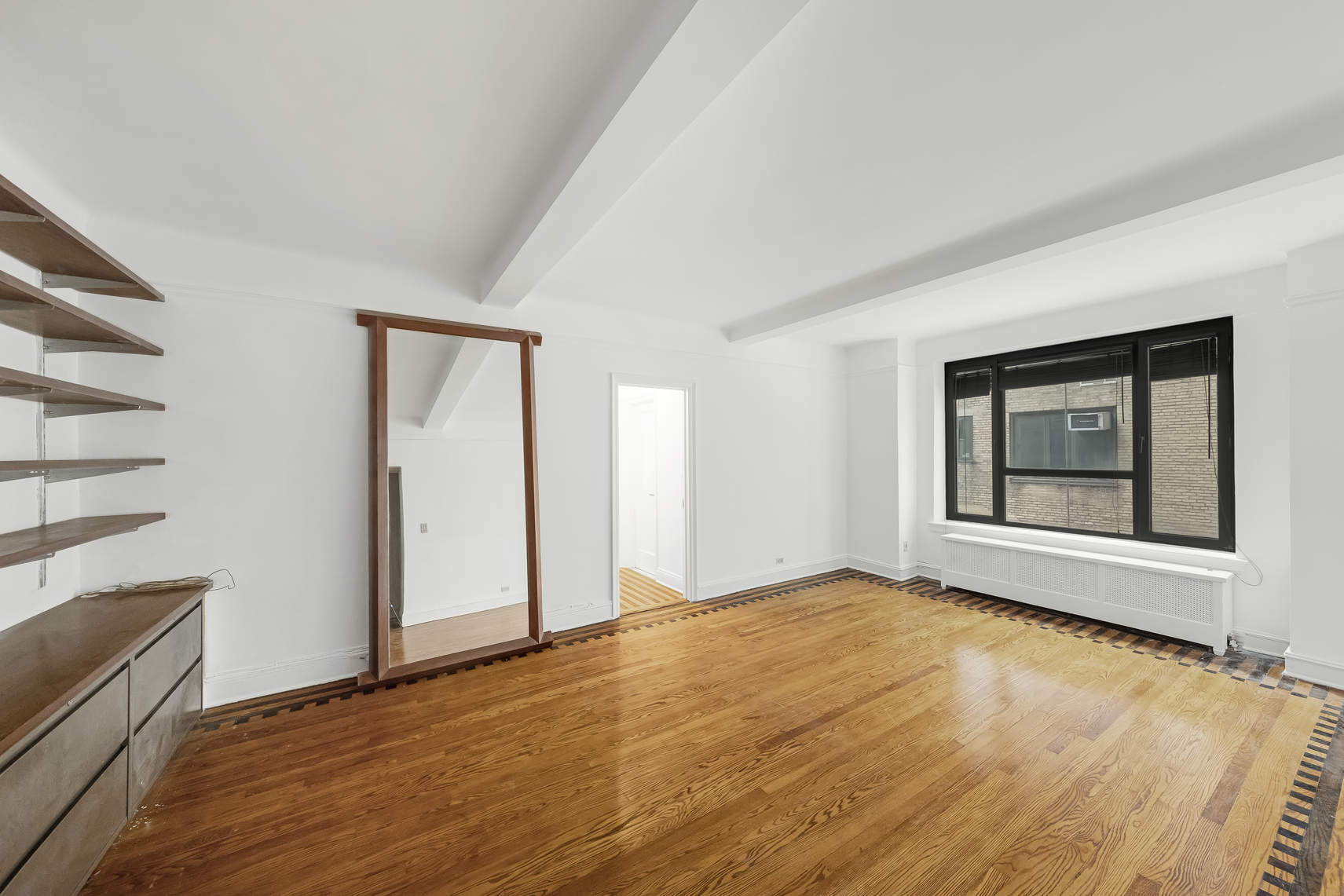 444 Central Park West, Unit 2H Manhattan, NY 10025 - Photo 5 of 16 a view of an empty room with wooden floor and a window