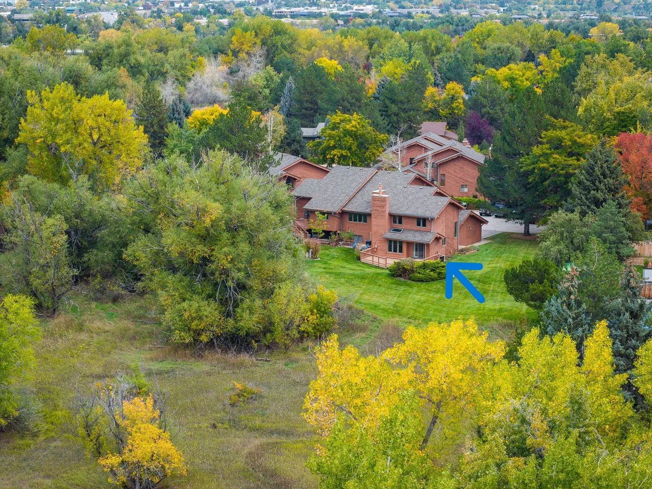 a aerial view of a house with a big yard and large trees