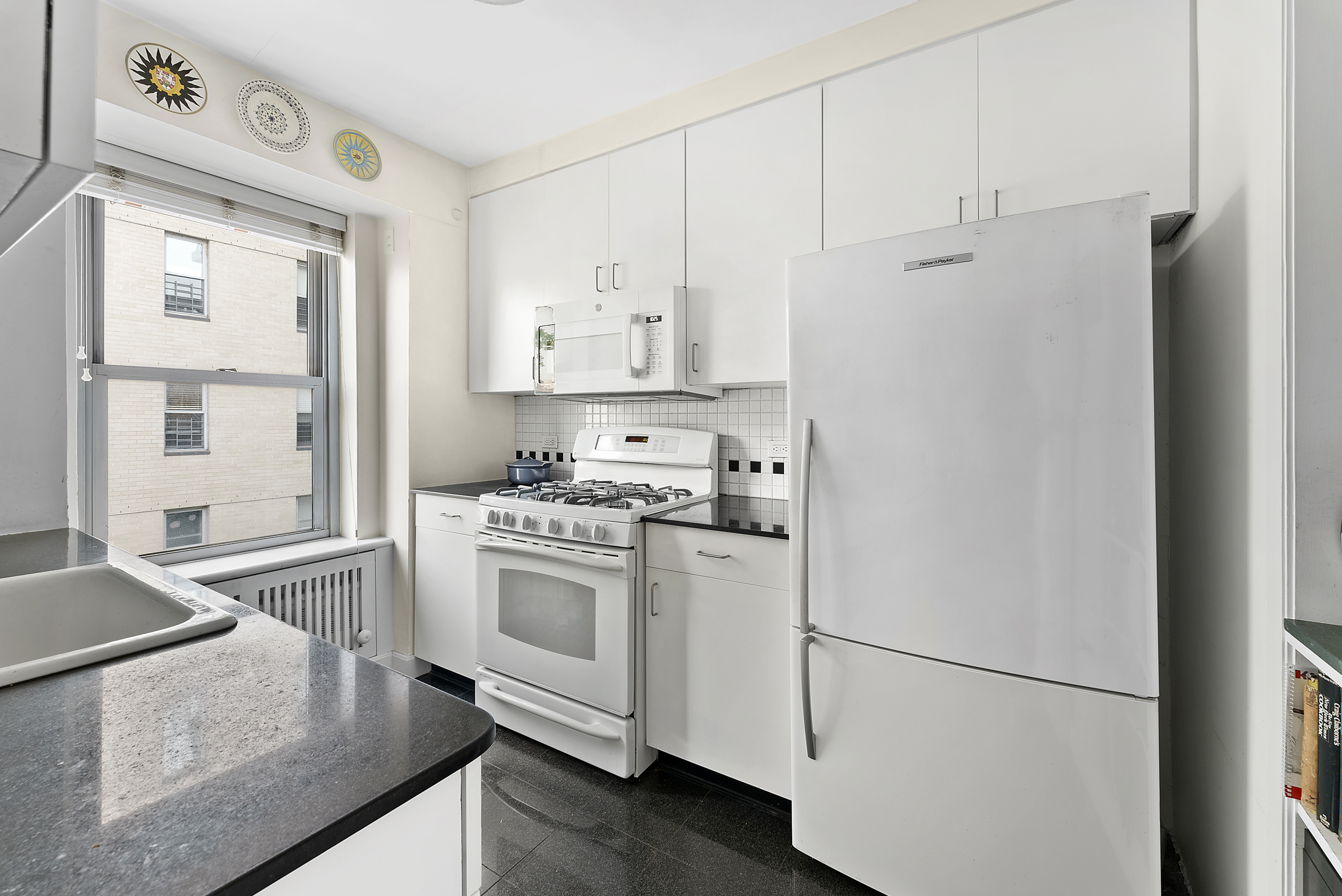 2 5th Avenue, Unit 55 Manhattan, NY 10011 - Photo 10 of 20 a kitchen with stainless steel appliances granite countertop a refrigerator sink and stove