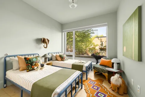 a bedroom with two beds and a large window with outer view