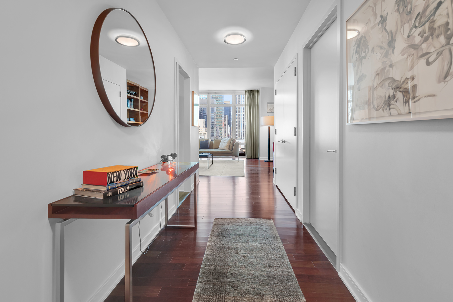 207 East 57th Street, Unit 25B Manhattan, NY 10022 - Photo 6 of 19 a hallway with wooden floor and a mirror