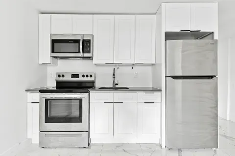 a kitchen with stainless steel appliances granite countertop a stove a microwave and a refrigerator