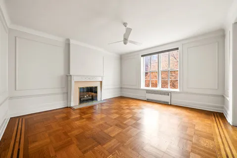 a view of an empty room with a fireplace and a window