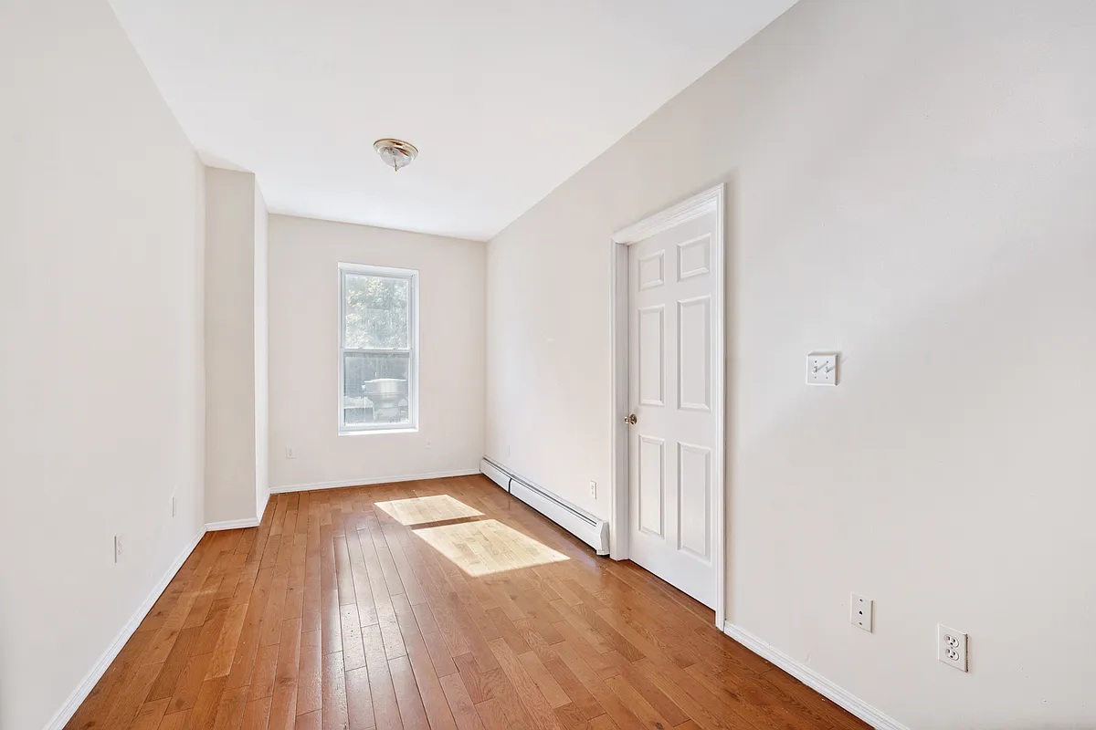 1402 Cortelyou Road, Unit 3 Brooklyn, NY 11226 - Photo 2 of 8 a view of empty room with wooden floor and fan