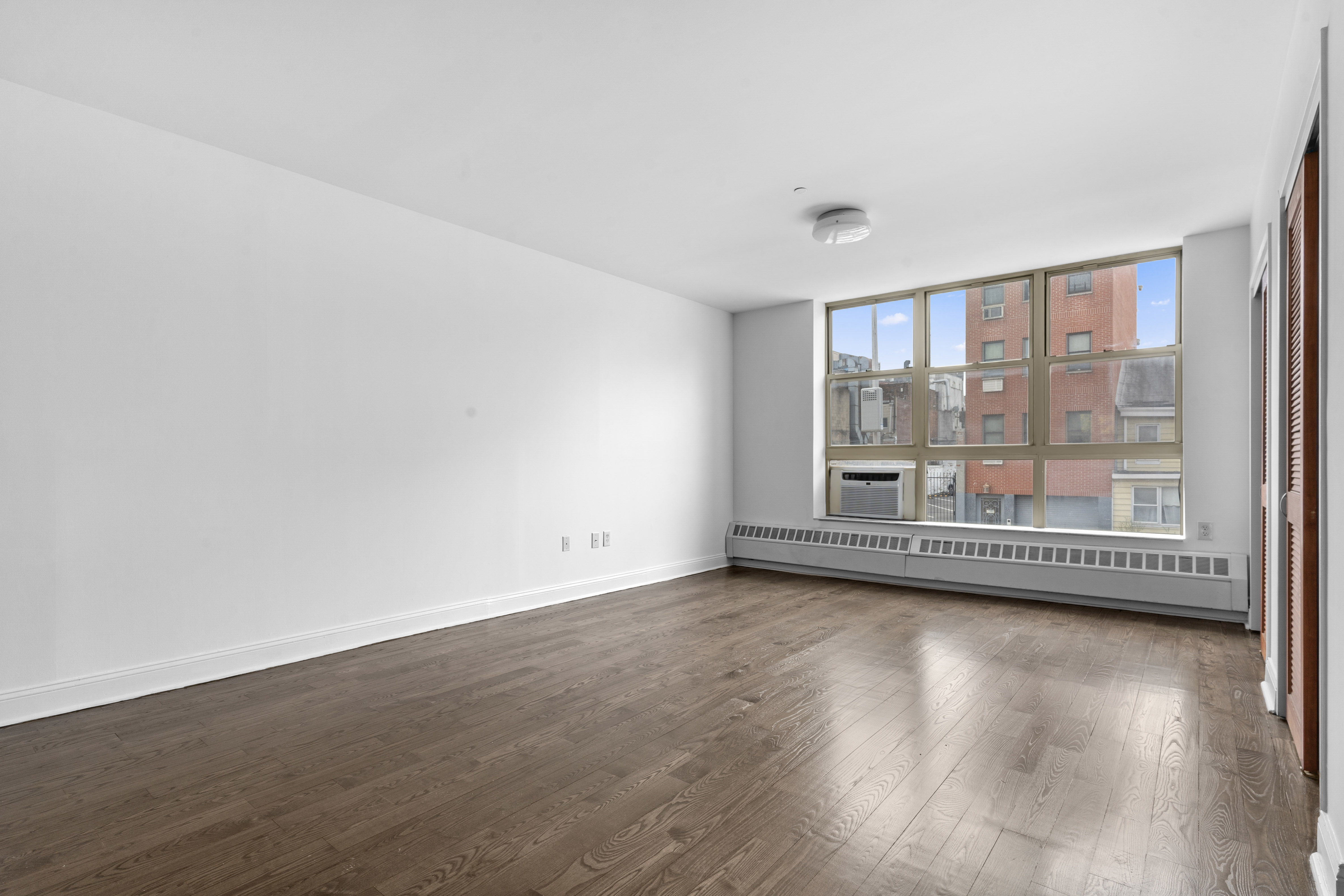 269 8th Street, Unit 2R Brooklyn, NY 11215 - Photo 2 of 14 wooden floor in an empty room with a window