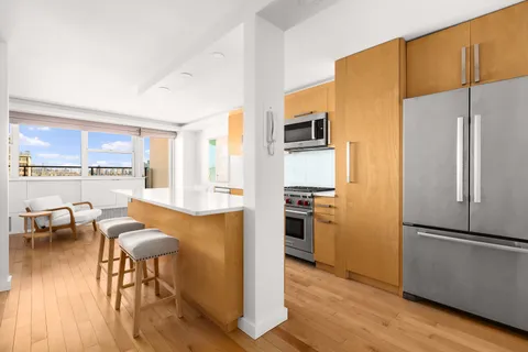 a kitchen with stainless steel appliances granite countertop a refrigerator and a stove top oven