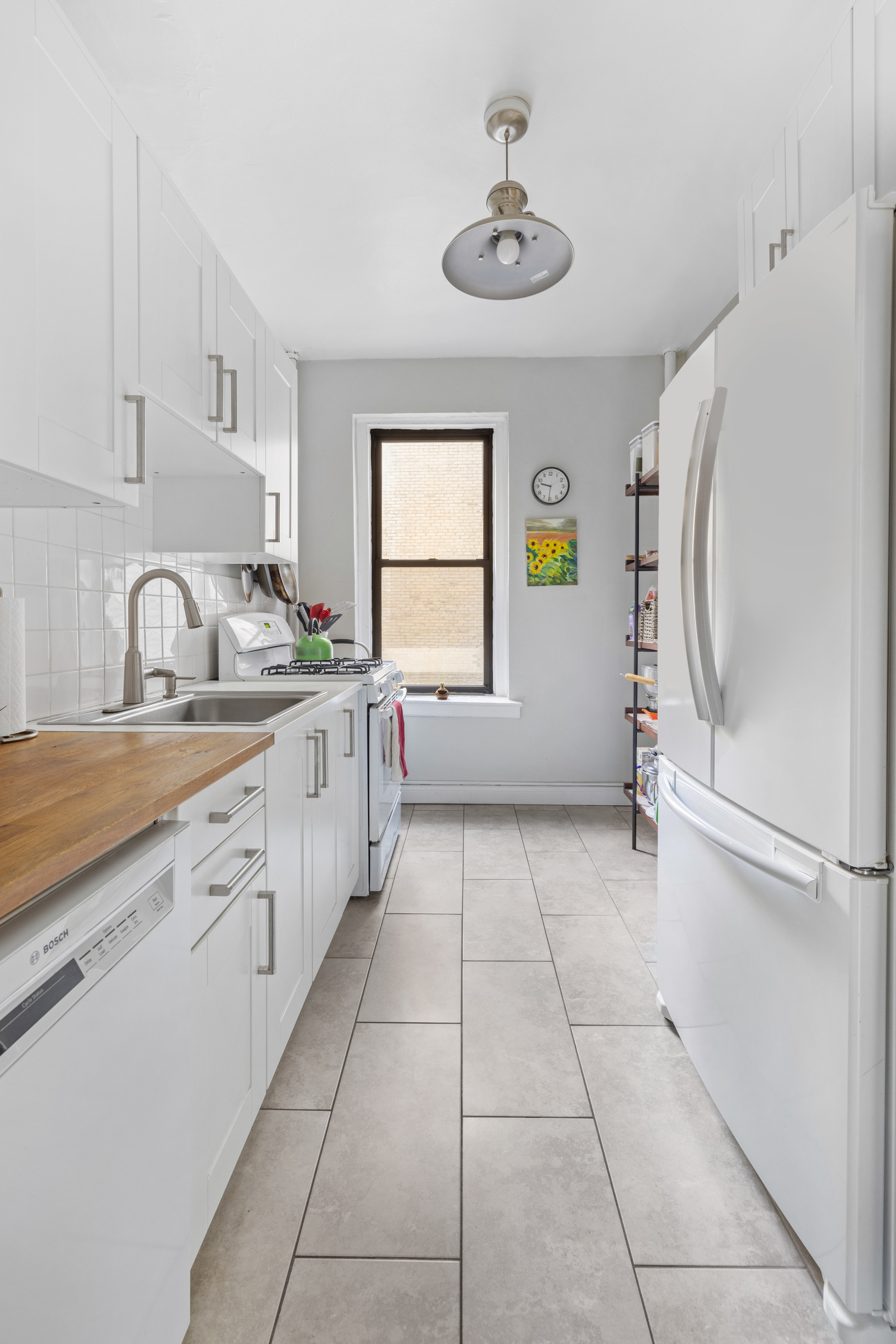 333 4th Street, Unit 2D Brooklyn, NY 11215 - Photo 4 of 7 a large white kitchen with a window and stainless steel appliances