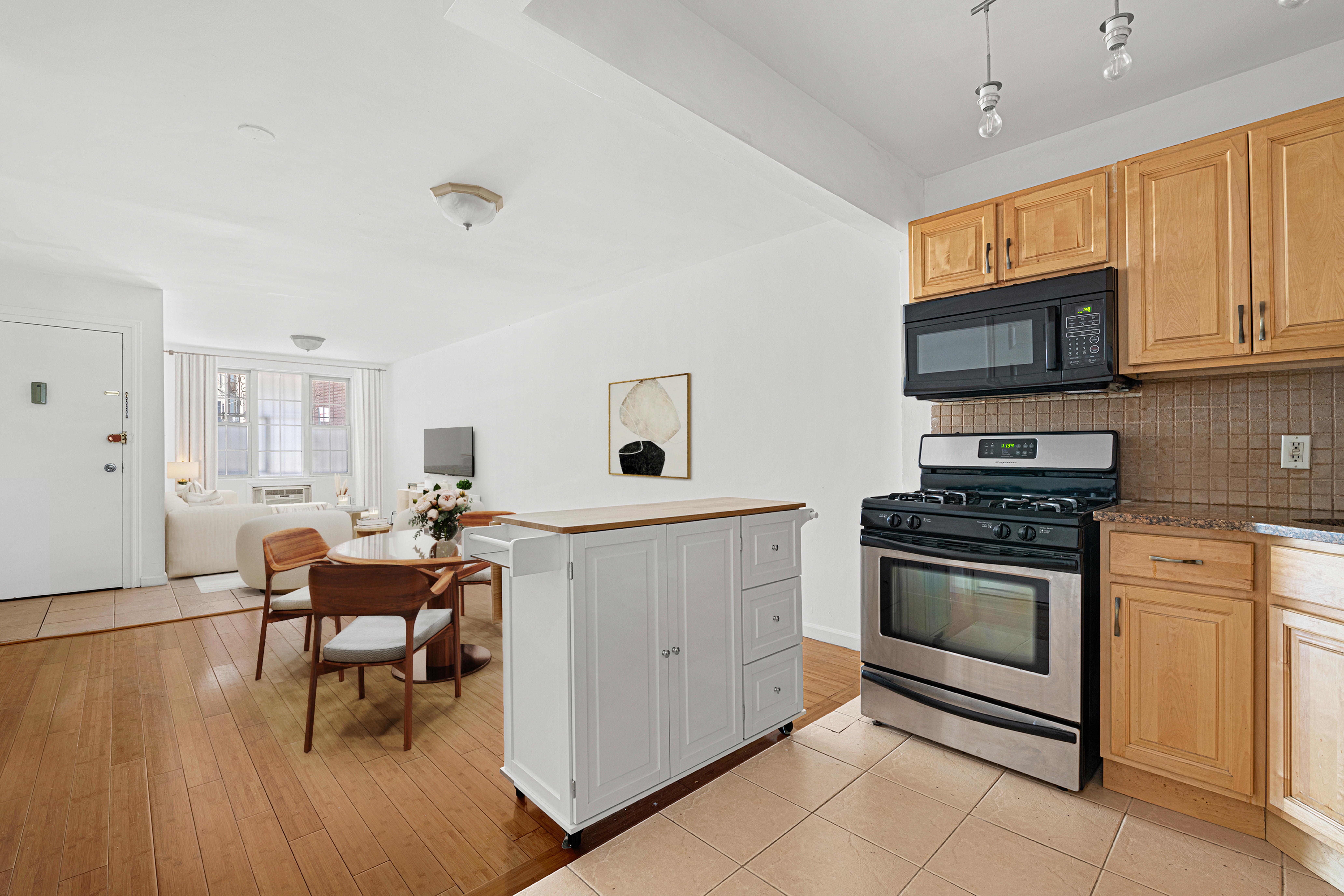 545 Gates Avenue, Unit 1 Brooklyn, NY 11216 - Photo 4 of 10 a kitchen with granite countertop a stove a sink and a microwave
