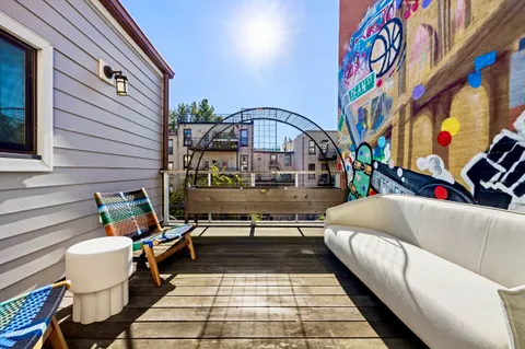 a view of a patio with couches a table and chairs with wooden floor