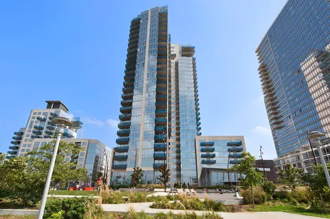 a front view of multi story residential apartment building with yard and parking space
