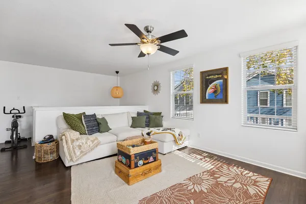 a living room with furniture kitchen view and a wooden floor