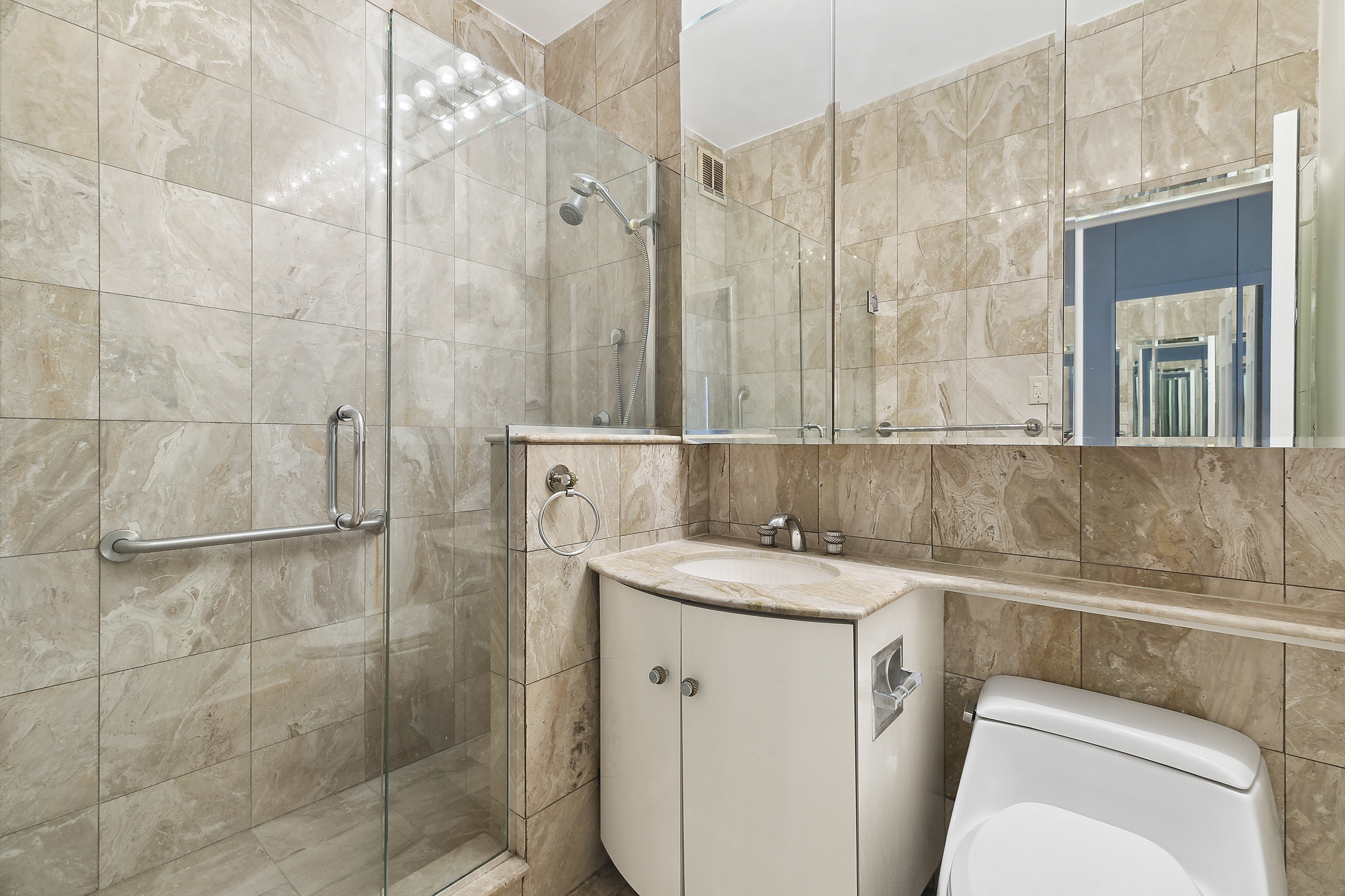 58 West 58th Street, Unit 4C Manhattan, NY 10019 - Photo 5 of 14 a bathroom with a sink a toilet and shower