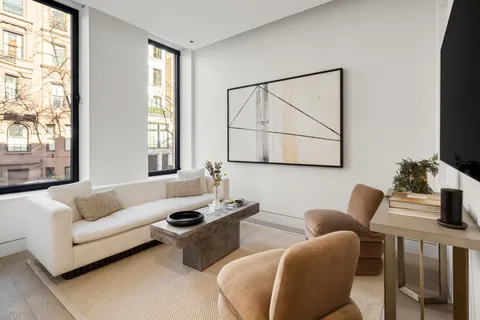 a living room with furniture a flat screen tv and a window