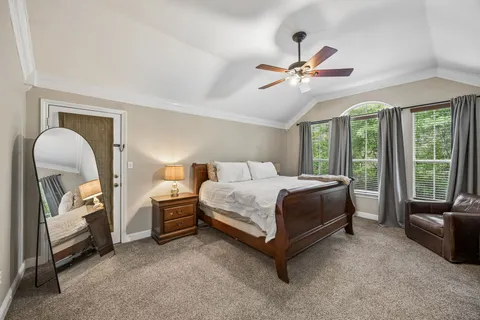 a spacious bedroom with a bed and a chandelier