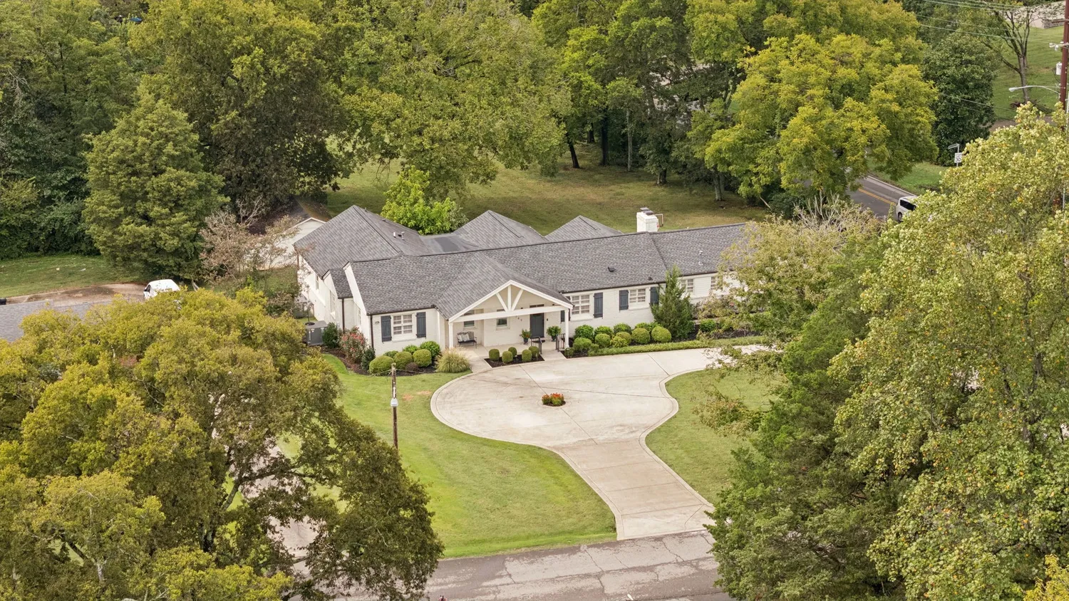 a front view of a house with yard and green space