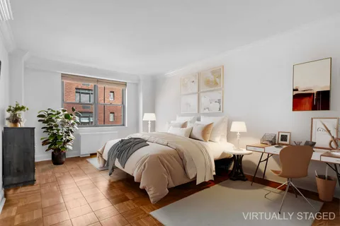 a bedroom with a bed and a potted plant