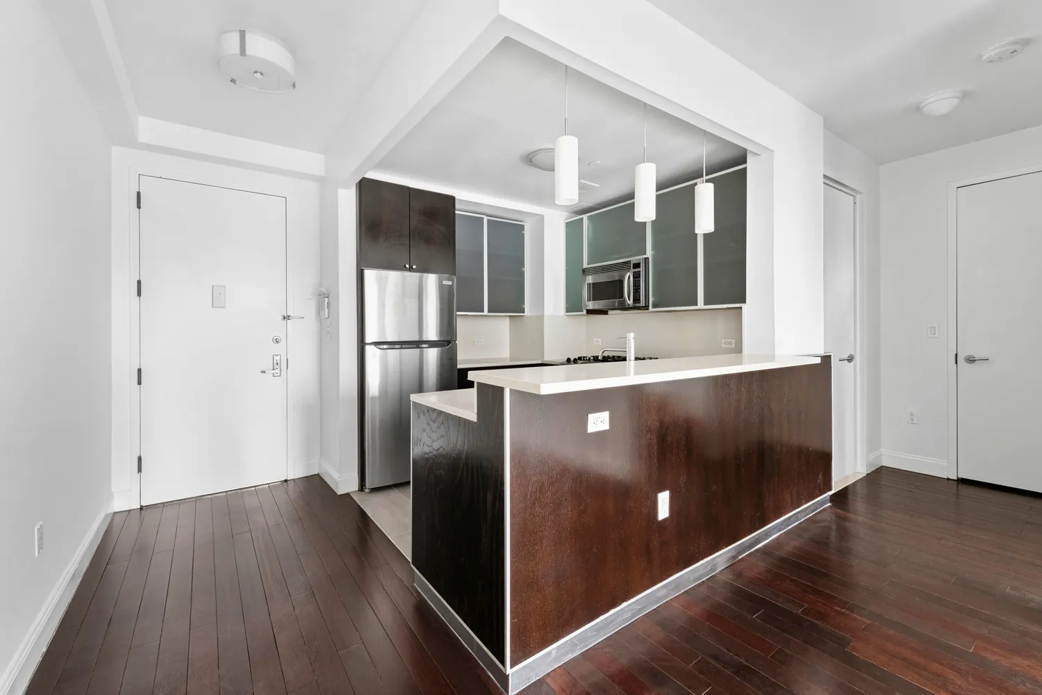 a view of a refrigerator in kitchen and wooden floor